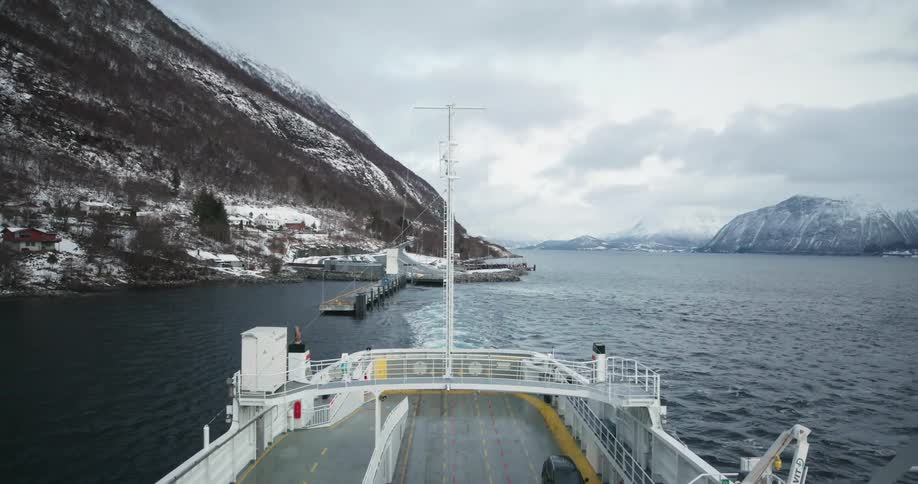 A large ship sails away from a port