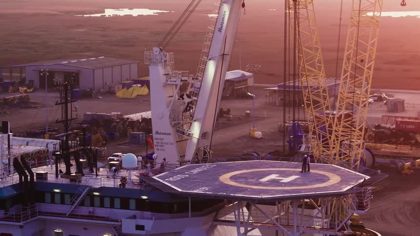 A pair of people standing on a helipad on the top of a building