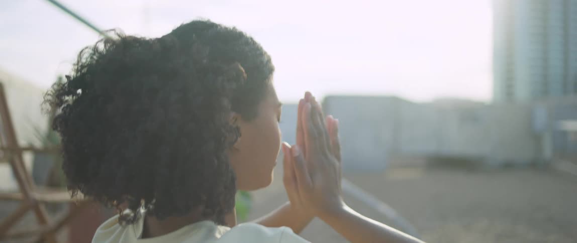 Black woman practices yoga outdoors