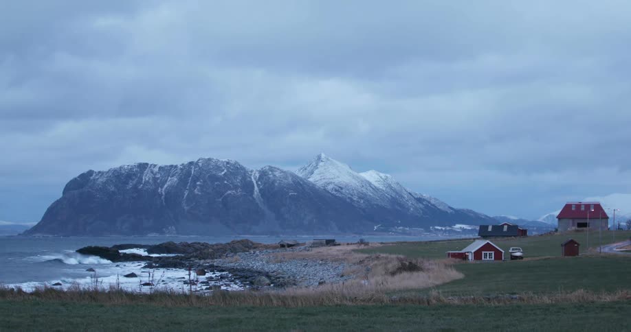 Several buildings and a boat sit right on a coastline