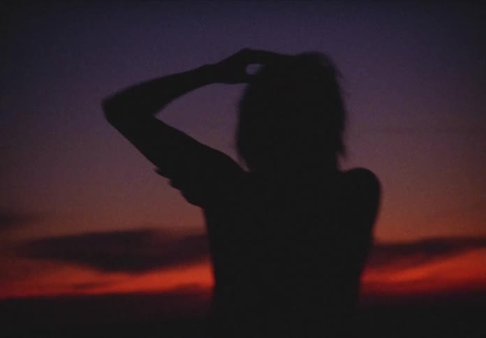 Silhouette of a woman dancing outdoors at night