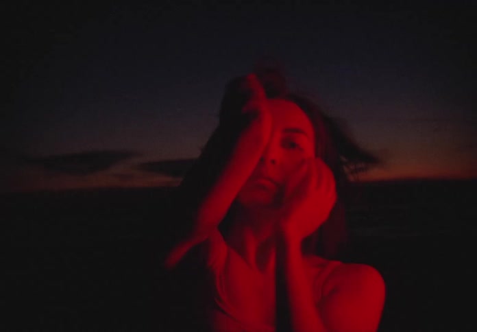 A white woman dances in the sunset