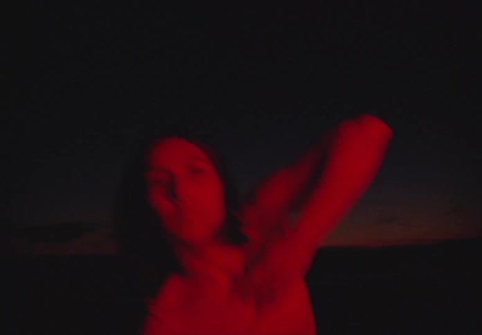 A hispanic teenager dances outside at night