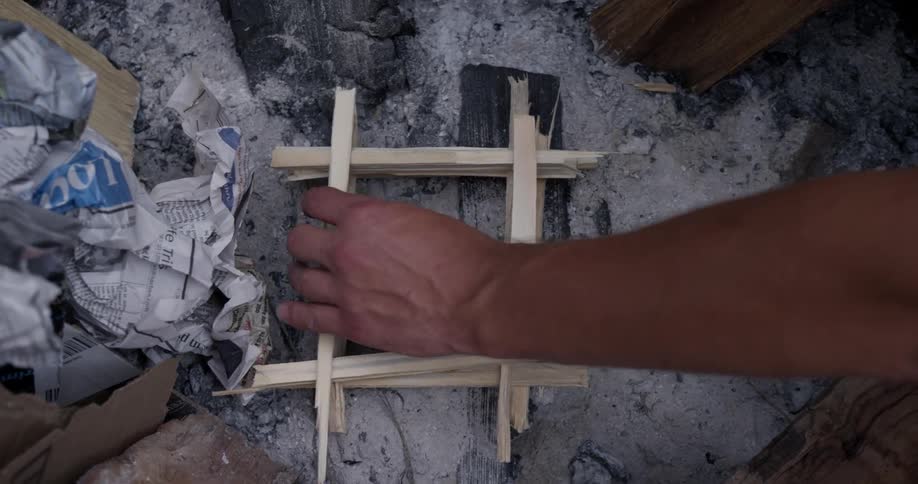 A person stacks sticks