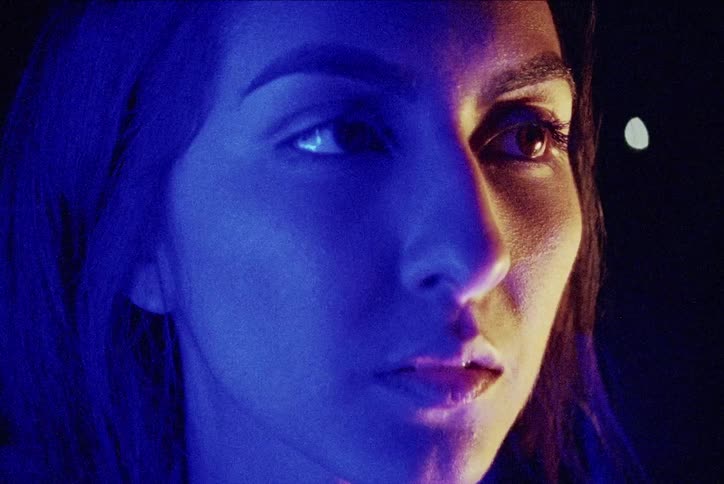 A hispanic woman blinks while looking off to her side