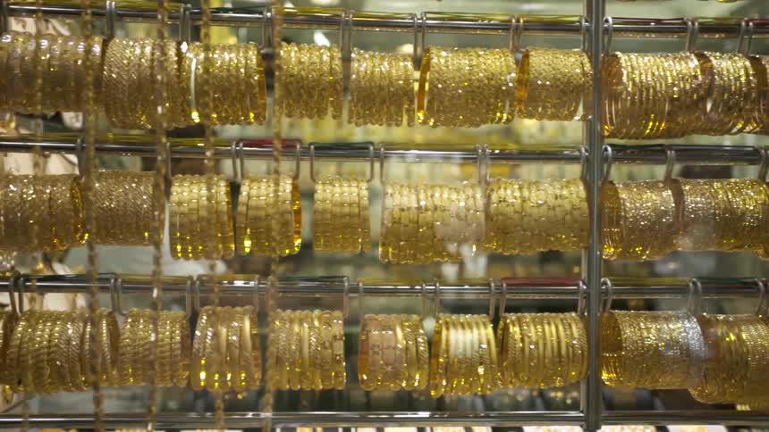 A row of bracelets and necklaces hang in the window of a jewelry store