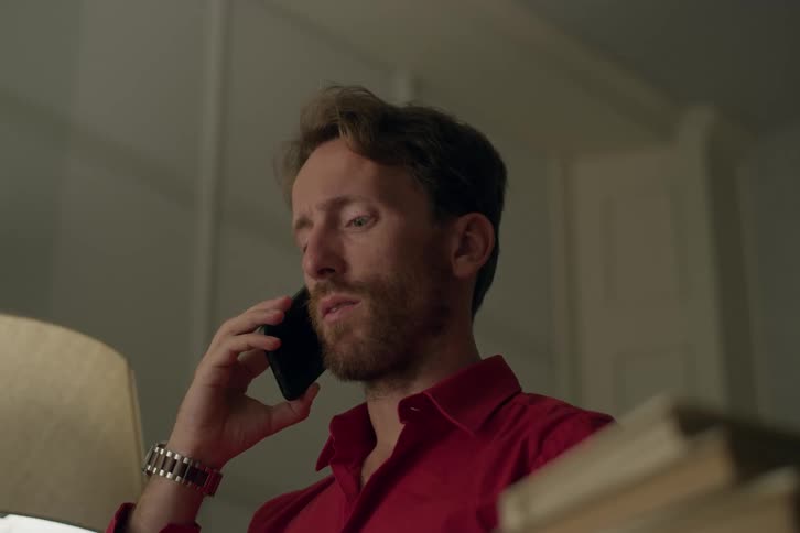 A man talking on a smartphone with a concerned look on his face