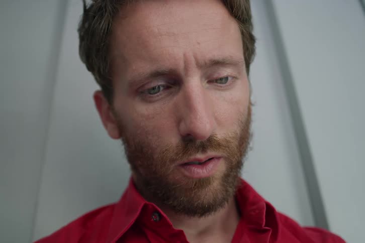 Bearded man looks down and breathes out