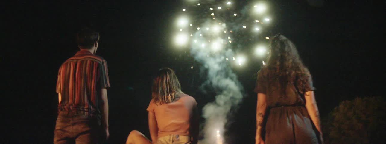 Three teenagers watch fireworks go off