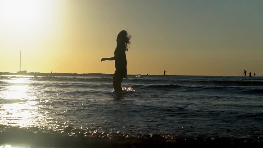 A woman plays in the water on the beach