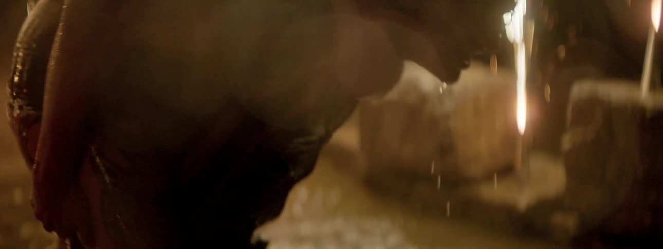 A man gives a piggyback ride to his girlfriend as theyre covered in water and playing in a puddle surrounded by lit fireworks