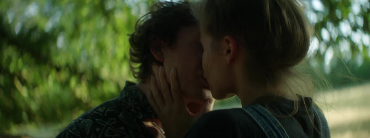 Two teenagers kissing outside
