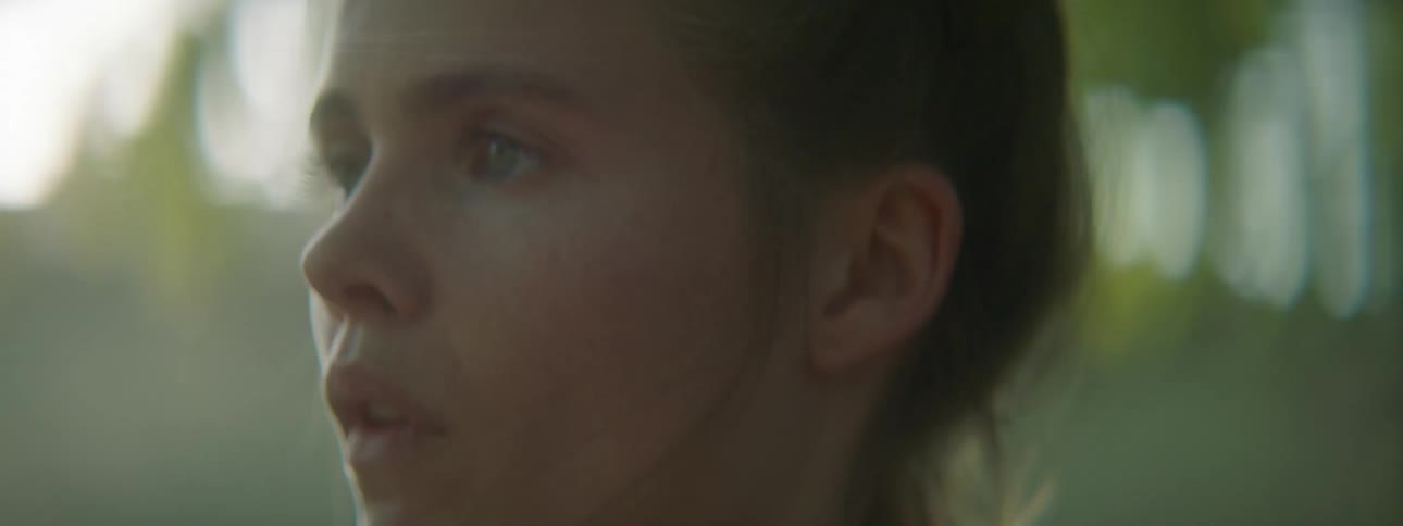Blonde woman looks at her boyfriend under a tree