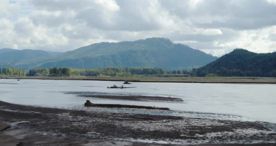 Lake sits near the mountains under a cloudy sky