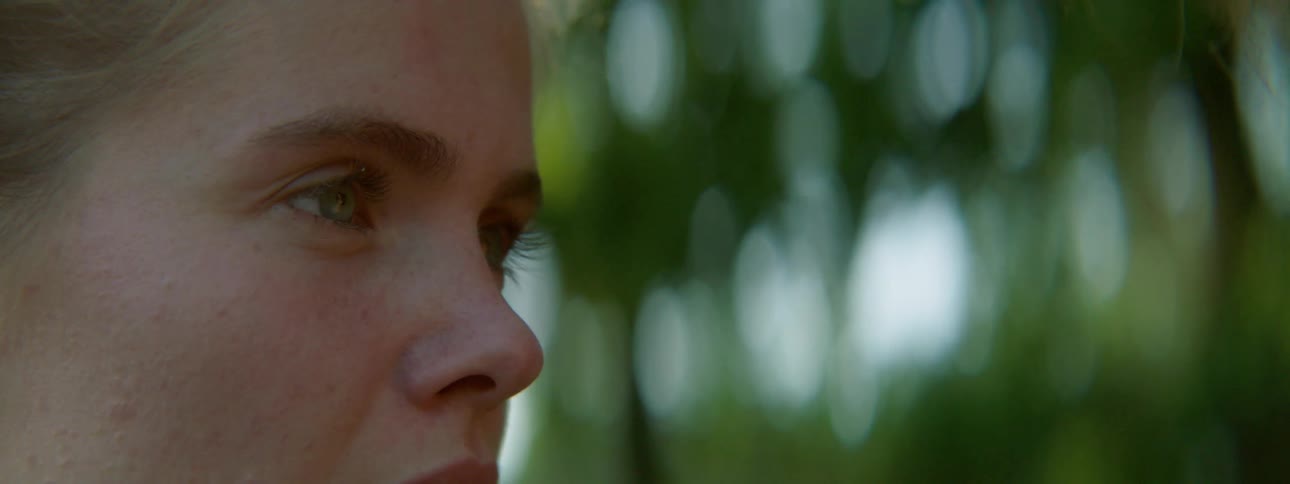 Man and woman look into each others eyes then kiss outdoors