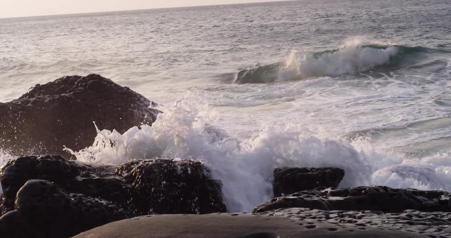 Close up of waves crashing on rocks on the coast