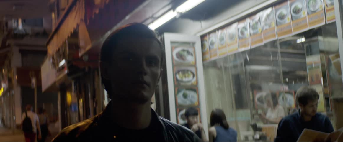 Man passes by an asian restaurant at night