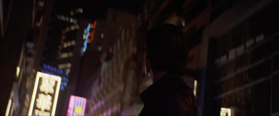 Man looks at the tall buildings at night