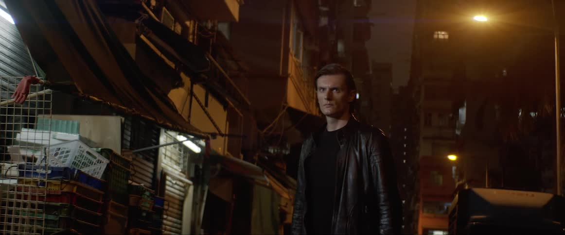 Man wearing a leather jacket walks down the street