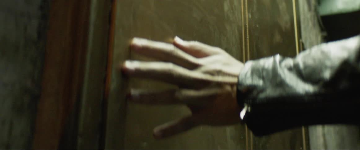 A person is tracing their hand on the wall as they walk by