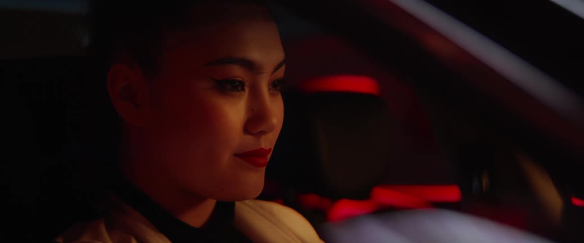 Asian woman sits in a car