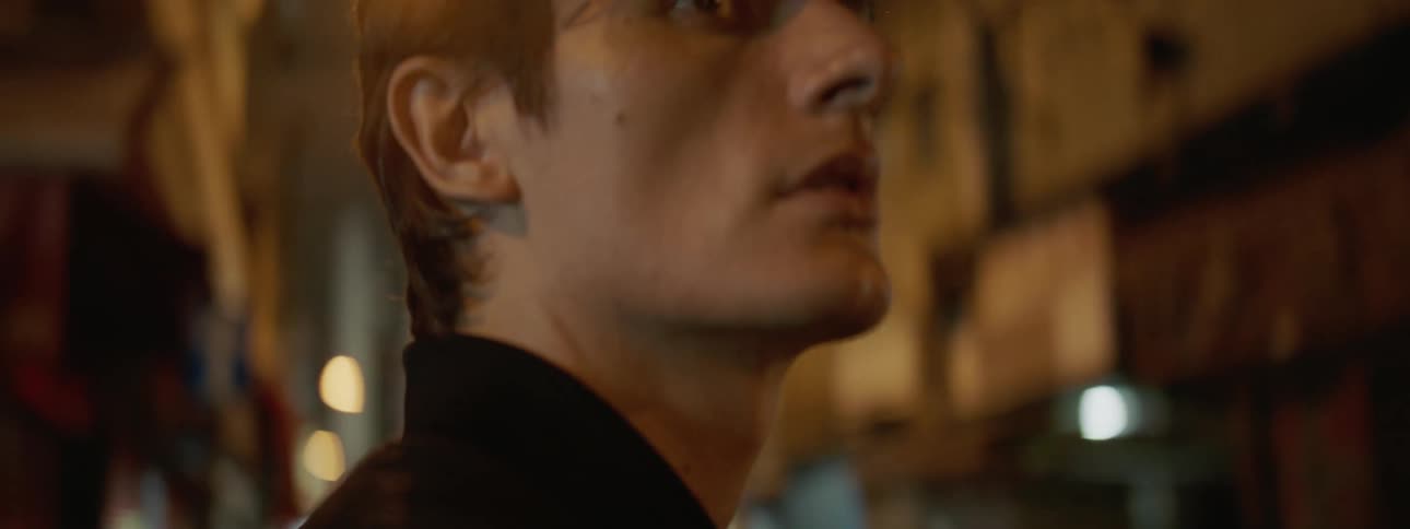Man stands and looks around in the street at night