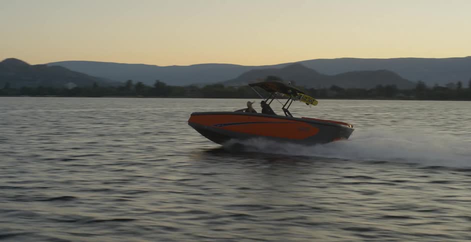 A man drives a boat and a woman sits next to him