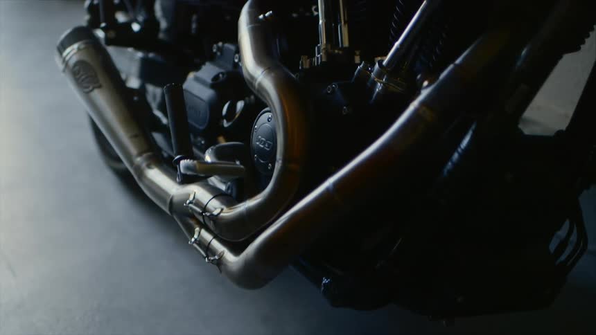 The exhaust pipe of a motorcycle attached to the engine