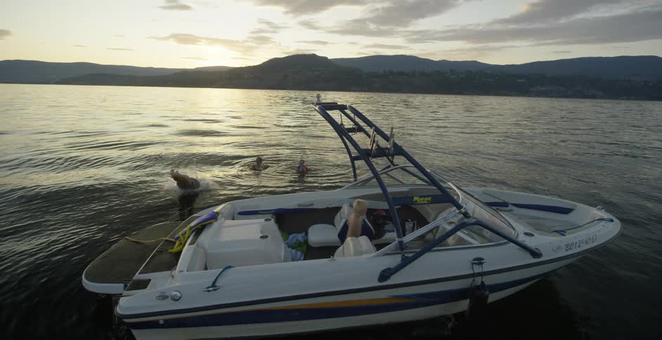 A man jumps from a boat into the ocean with other people