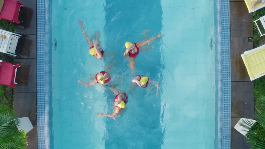 Synchronized swimmers performing a routine in a small pool