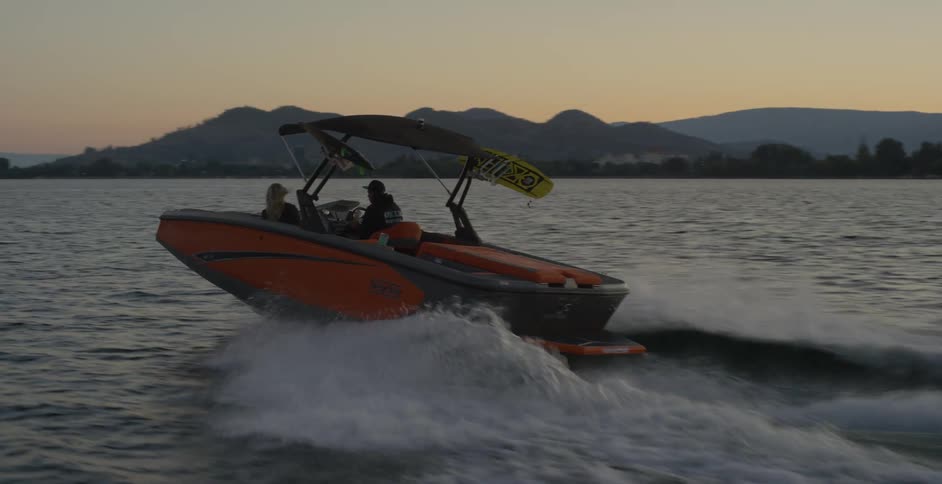 Two people ride a boat across a body of water