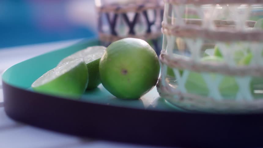 Sliced fruit halves rest near whole fruit and basket on tray
