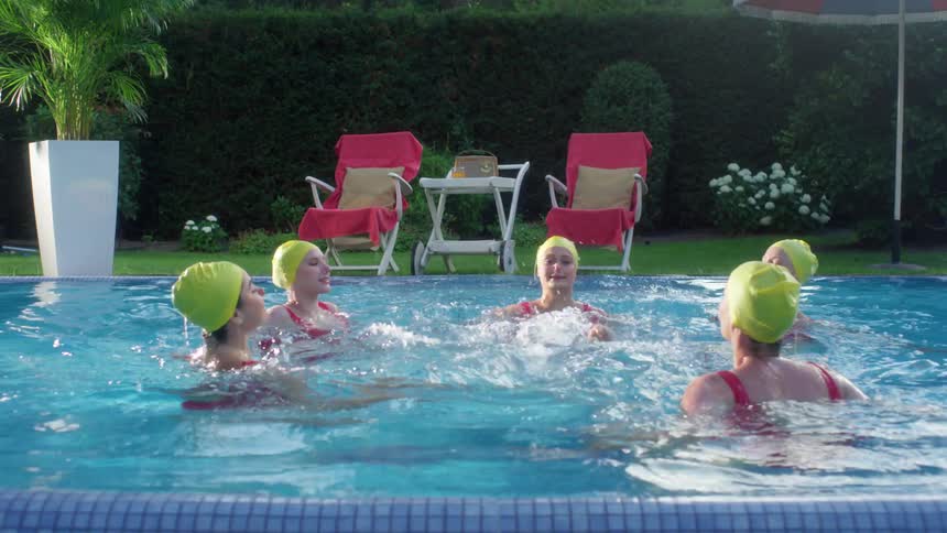 Five teens do synchronized swimming in a pool