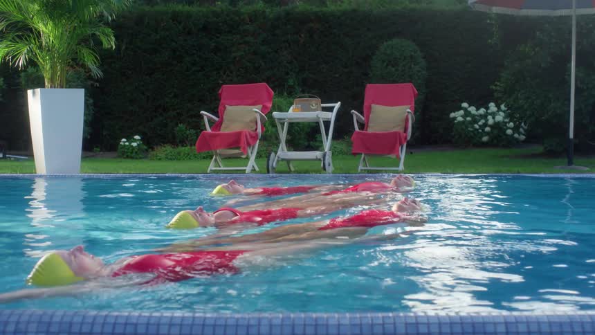 Five synchronized swimmers float in a pool