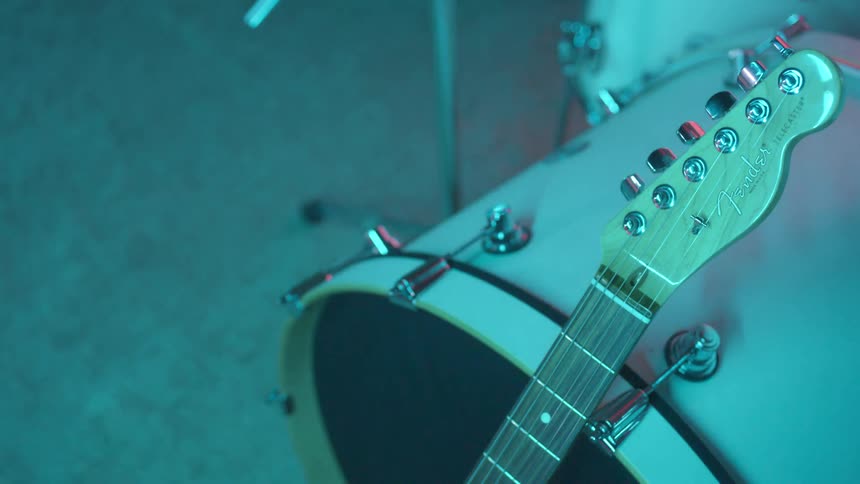 A guitar rests on a drum