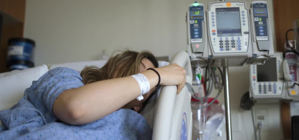 A white woman sleeps in a hospital bed