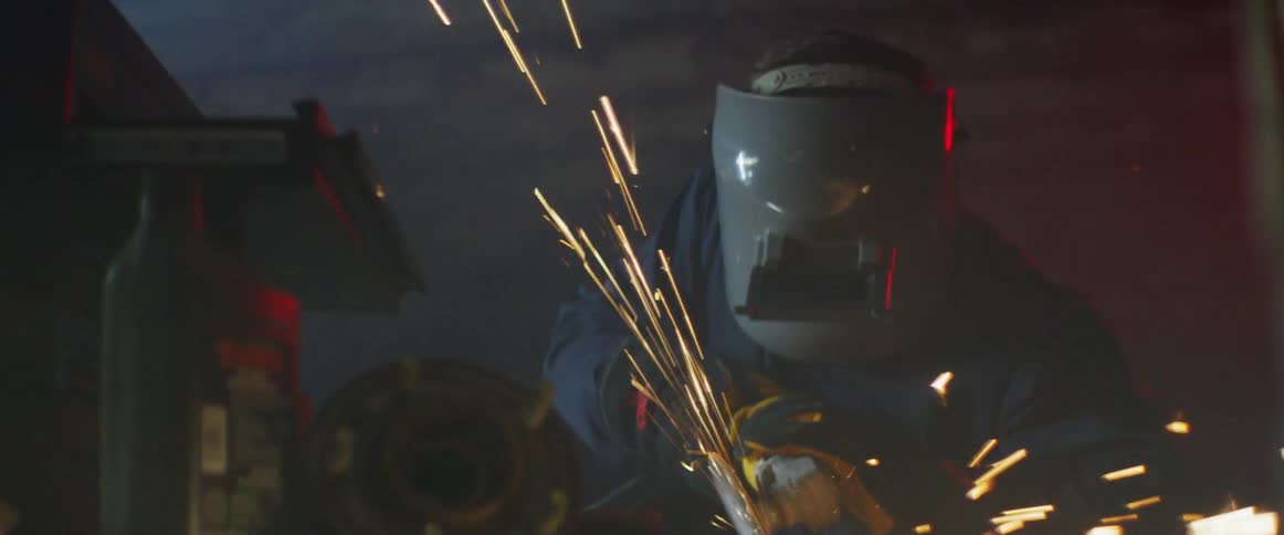 Man wearing a helmet with sparks flying around him