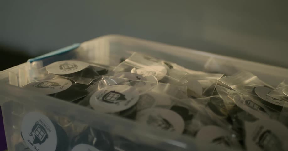 A plastic bin contains bags filled with spools