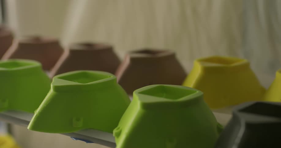 Colored plastic bowls with spouts on display on shelf in a store
