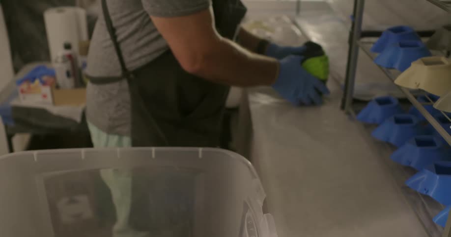 Man loading plastic pieces in a plastic transparent container