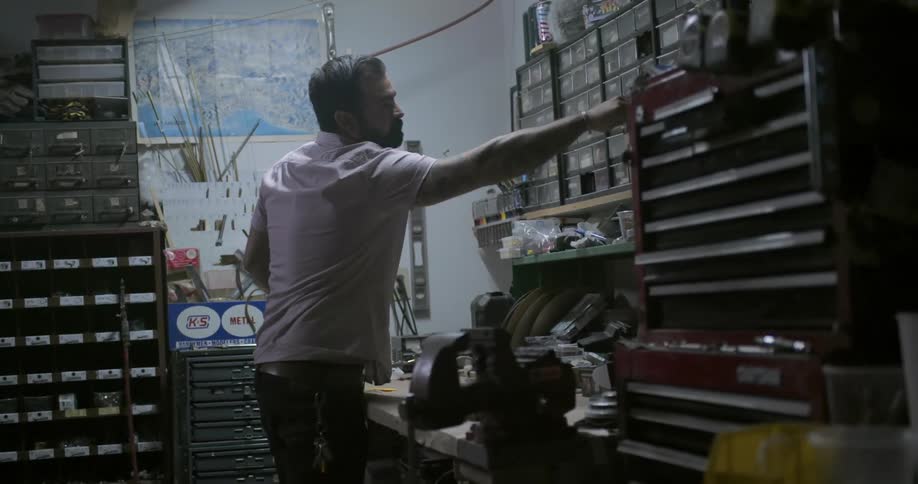 A man working in a garage looks for parts