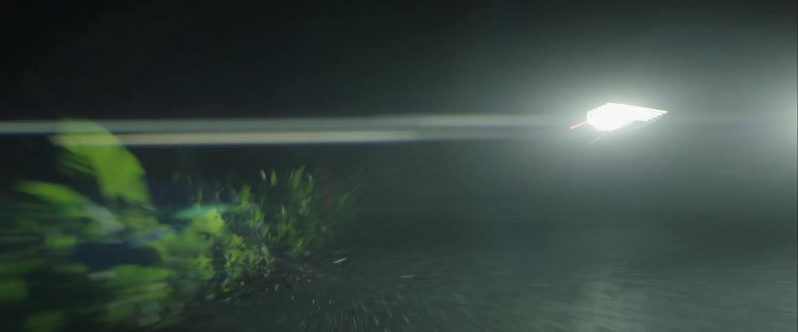 A vehicle is driving down a small road at night