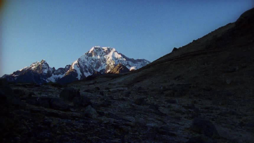 A mountainous valley gives way to a peak with snow on it