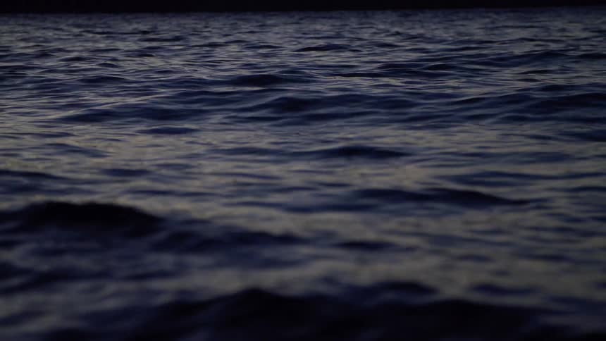 Waves roll and ripple across a body of water