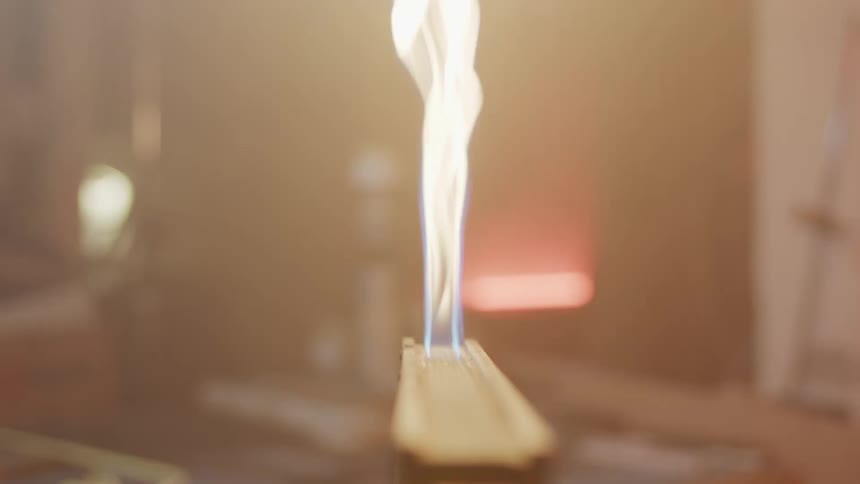 A man uses a lighter to lights something else on fire