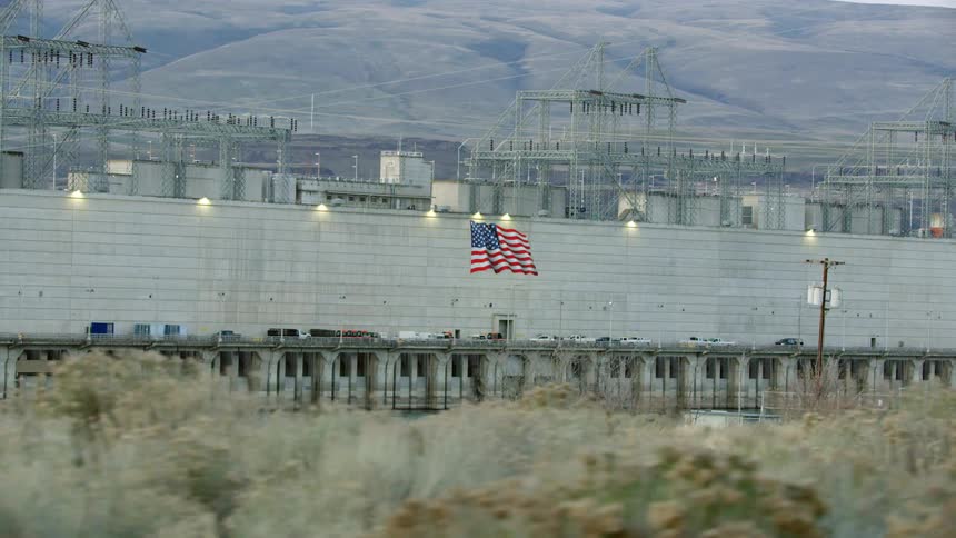 An american flag on a wall surrounding a large hyrdo electric generation station