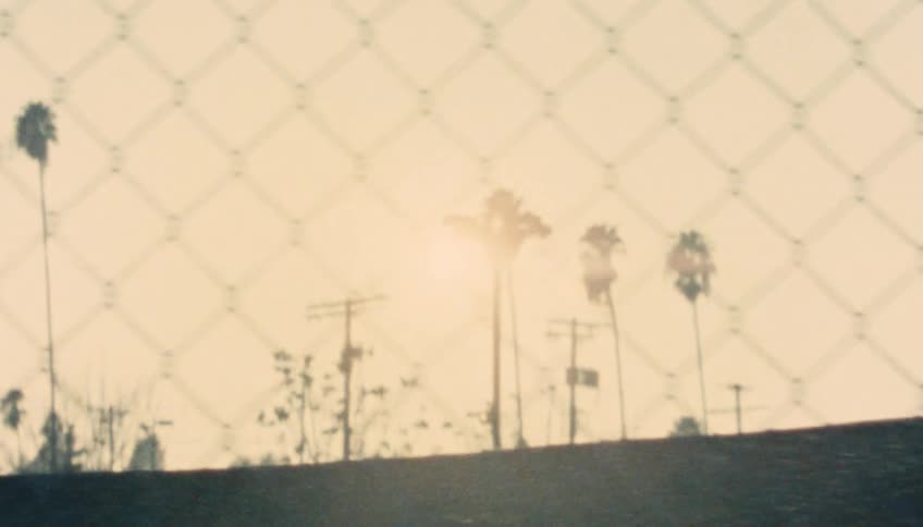 A chain link fence protects a full parking lot