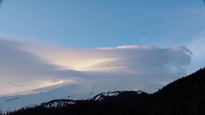 Time lapse of winter storm clouds blowing off the summit of Mount Hood as the sun sets  revealing the dynamic and harsh weather of the Cascade Mountains