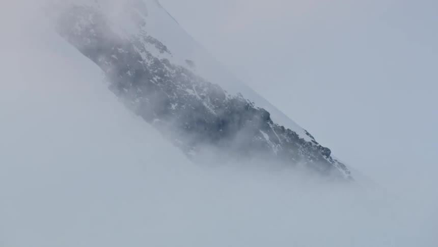 Real time tight shot of high winds blowing snow off the side of Mount Hood in this extreme weather winter storm shot