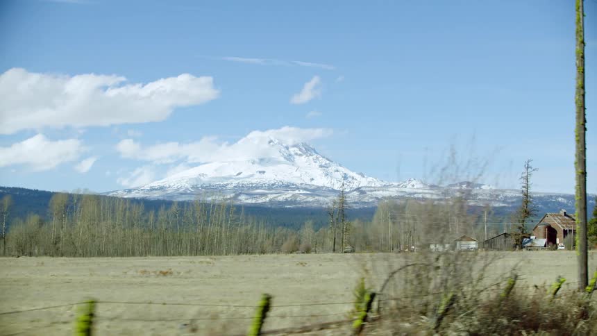 Rural ranch land with old farm houses and barnes in the foreground and beautiful Mount Adams in the background in mid winter